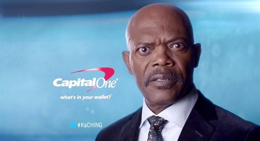 A screenshot from a Capital One advertisement showing Samuel L. Jackson looking straight at the camera. A Capital One logo is to the left of him with the text "What's in your wallet?" underneath. At the bottom of the image is a Twitter logo with the hashtag #KaCHING written next to it.