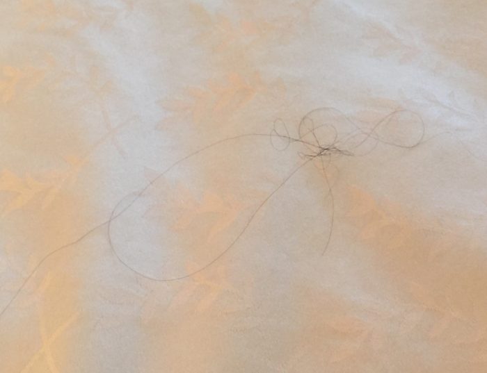 a white sheet with a black thread on it