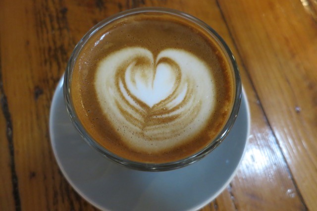 a cup of coffee with a heart shape foam in it