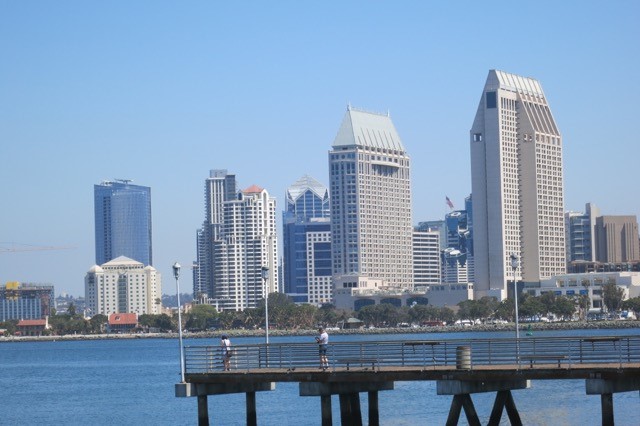 a city skyline with a pier and a body of water
