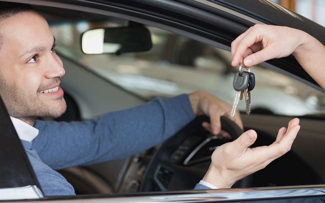 a man in a car handing over keys to another man