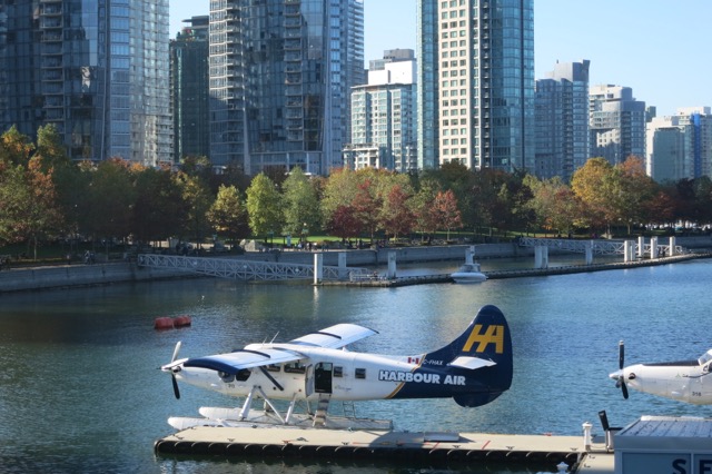 a seaplane on a dock in front of a city