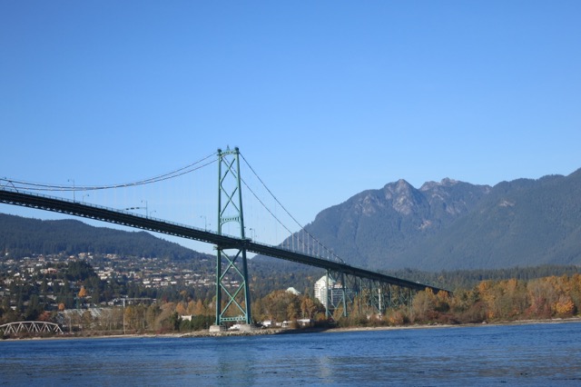 a bridge over water with mountains in the background