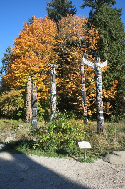 a group of totem poles in a forest