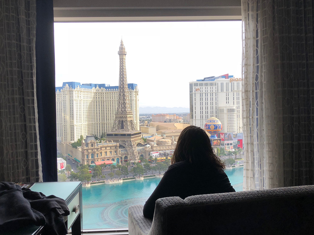 a woman sitting in a chair looking out a window at a city