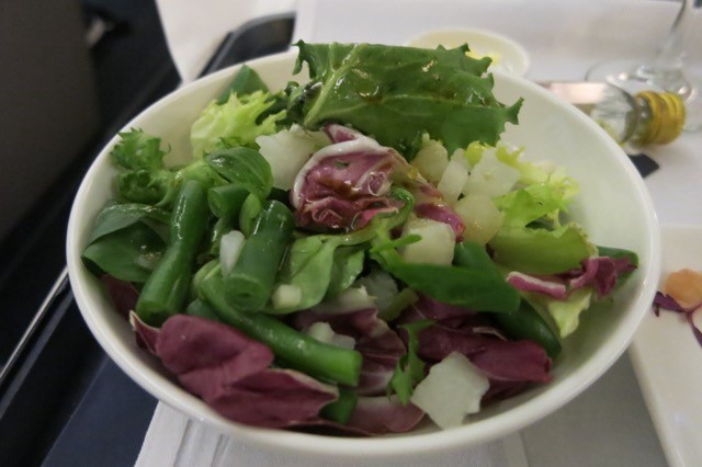 a bowl of salad with green beans and lettuce