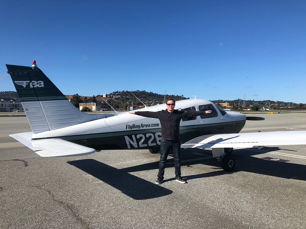 a man standing in front of a small plane