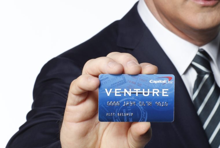 a man in a suit holding a credit card