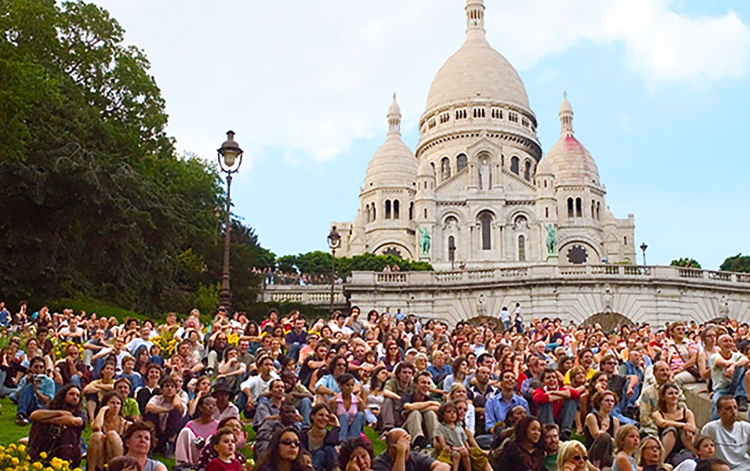 a large group of people sitting on the steps of Sacré-Cœur, Paris